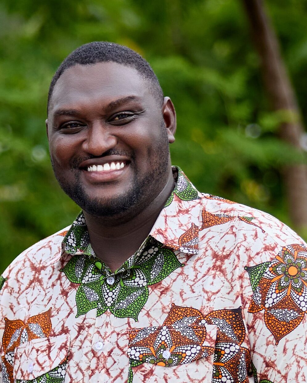 Two Ghanaian men smiling outdoors, wearing traditional kaftans, capturing modern African fashion.